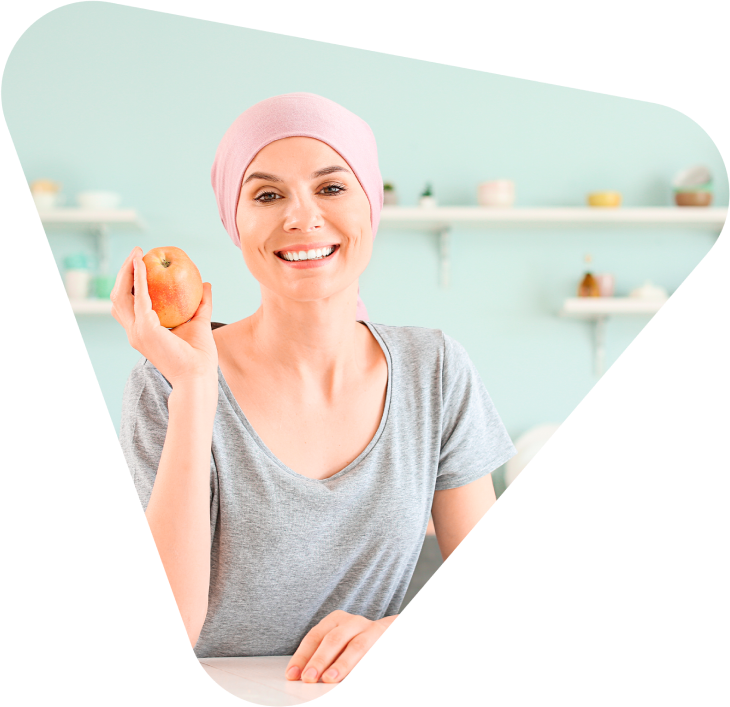 Imagem ilustrativa de uma paciente segunrando uma maça e sorrindo